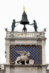 Sulla sommità della Torre dell’Orologio i famosi “Mori di Venezia”, soprannominati così per il loro colore bruno dai Veneziani. Posti alla sommità della Torre su una terrazza, sono due statue di bronzo raffiguranti due pastori che battono con una mazza le ore su una grande campana. Accanto al Leone di San Marco c’era la statua del Doge Agostino Barbarigo che inaugurò l'Orologio nel 1499. La statua fu distrutta nel 1797, con l'occupazione francese della Repubblica Veneta.