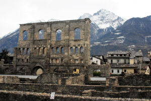 Suggestiva immagine del teatro romano di Aosta con le “grandi” montagne che sovrastano la città